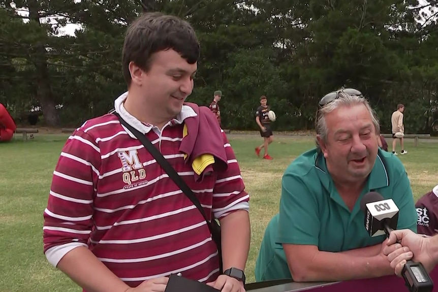 Father and son speak into an ABC microphone