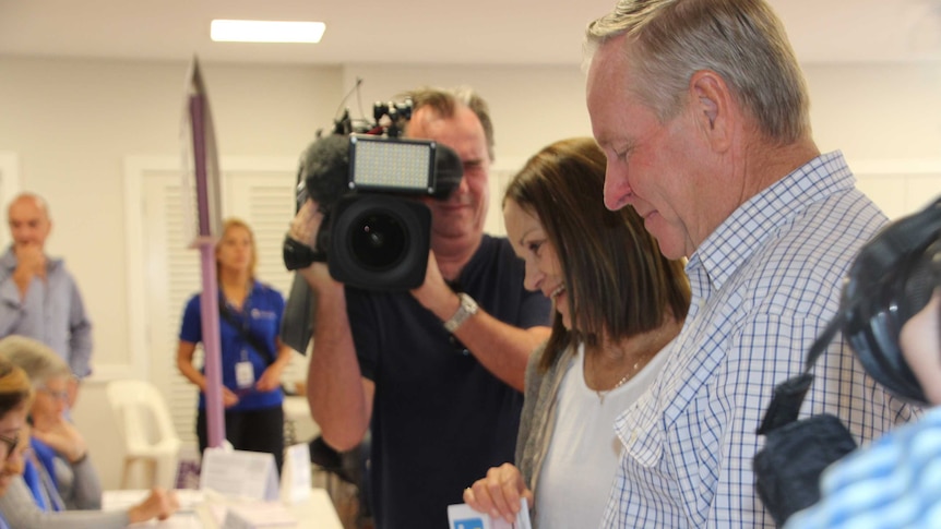 A side shot of Colin Barnett at a ballot box with a cameraman in the background.