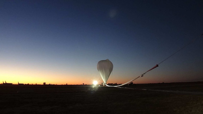 A helium balloon prepares to launch at sunrise in Alice Springs.