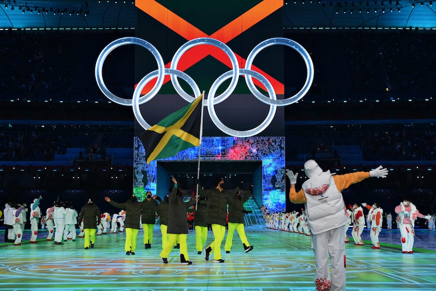 A team of Jamaican flag bearers hold up their flag during the opening ceremony of the Beijing winter Olympics.