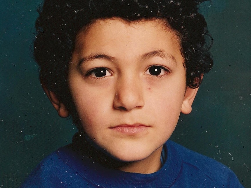 A school photo of a young boy with curly hair