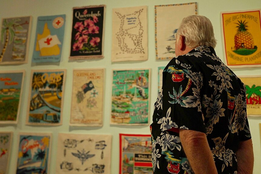 Looking at tea towels displayed on a wall. 