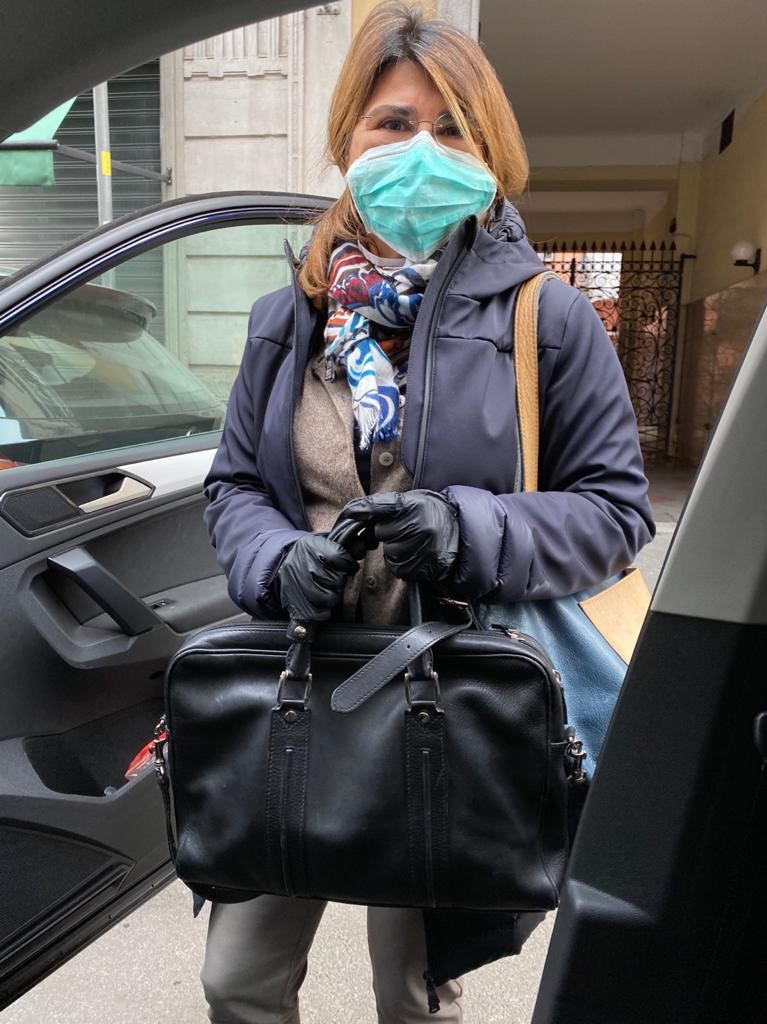 Emma getting into the car in a face mask.