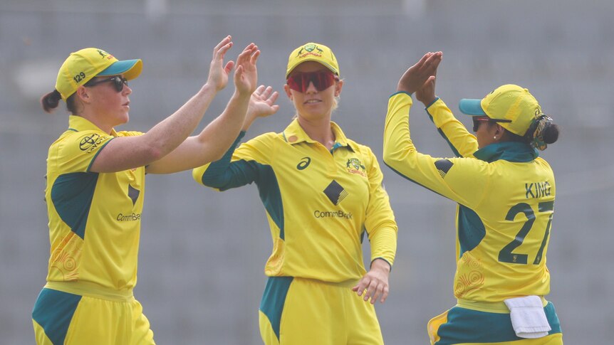 Grace Harris, Ash Gardner and Alana King high five each other during an ODI against Bangladesh.