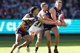 Crows and Magpies players contest for the ball during a 2024 AFL match at the MCG.
