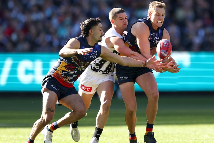Crows and Magpies players contest for the ball during a 2024 AFL match at the MCG.