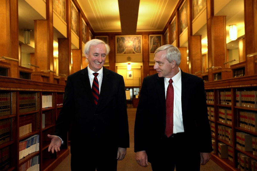 Jeff Rosen and Richard Donoghue walk through a library.