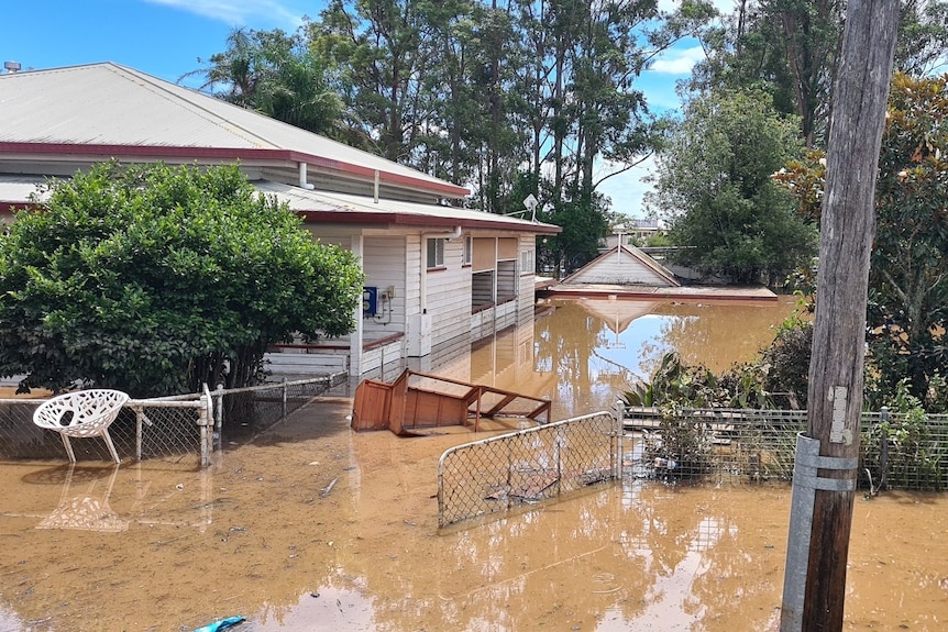 A white home surrounded by floodwater