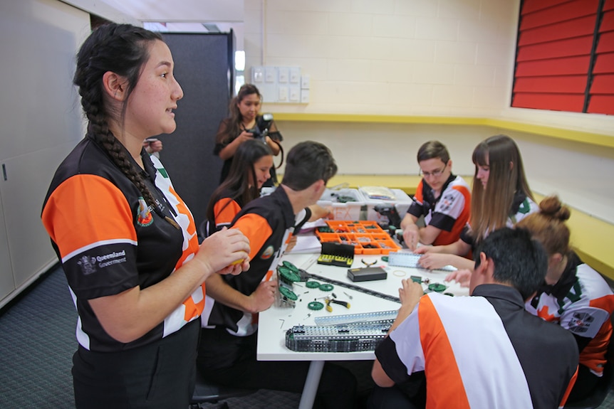 Maya Wood watches a team of Merrimac State High School students build robots