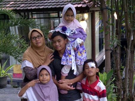 42-year-old Puji Kuswati poses with her four children