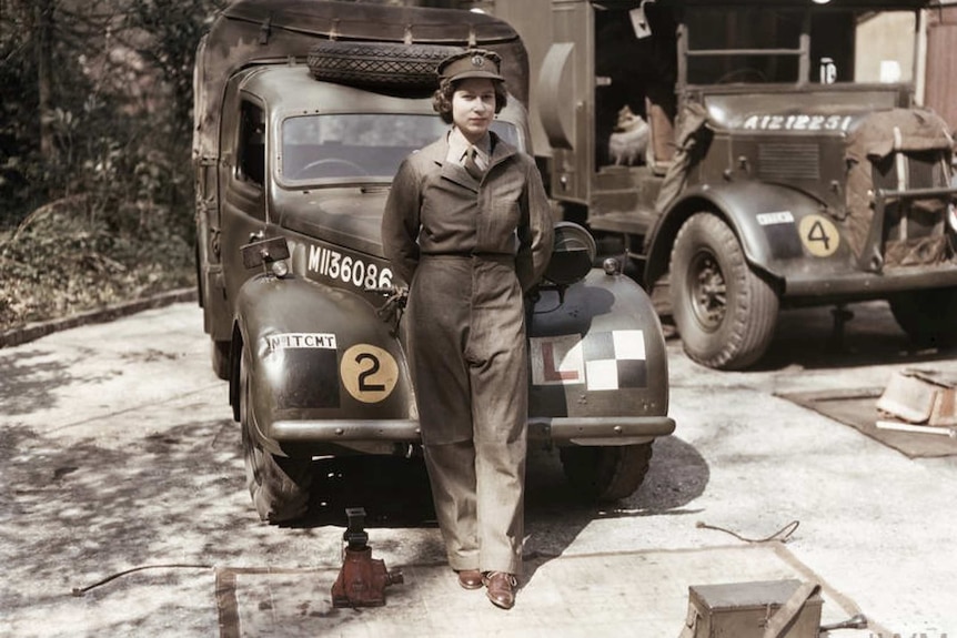 Princess Elizabeth, a 2nd Subaltern in the ATS, wearing overalls and standing in front of an L-plated truck.