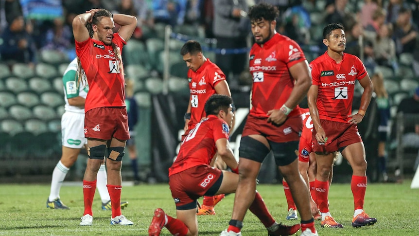 Super Rugby players with hands on their head or on their haunches look disappointed after a loss.