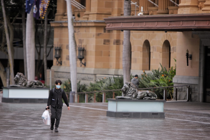 Man wearing a mask in King George Square in Brisbane city during lockdown.