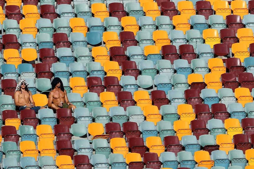 Fans sitting in an otherwise empty part of the stands at the cricket in Brisbane.
