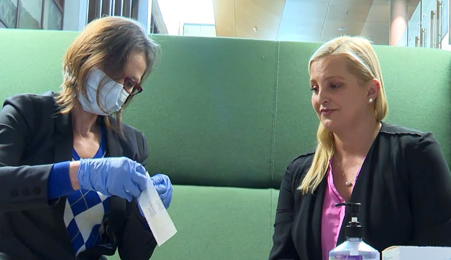 a woman wearing a mask and holding a swab 