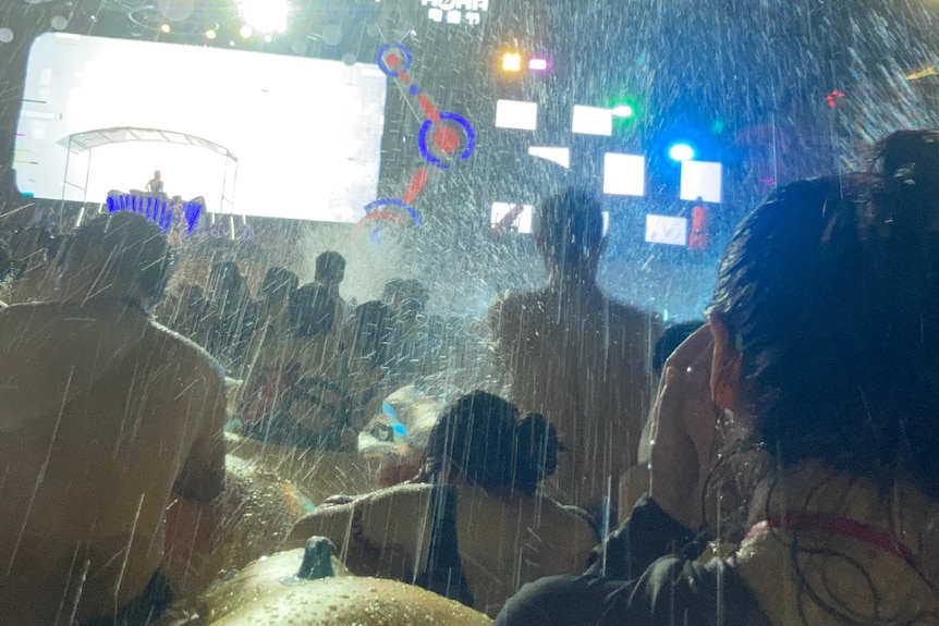 Attendees are sprayed with water at a pool party music festival in Wuhan.