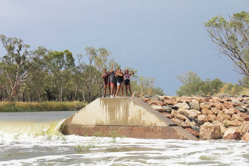 Kids splash around the overflowing weir at Brewarrina.