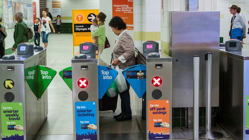A commuter walks through an automatic ticket gate at a train station