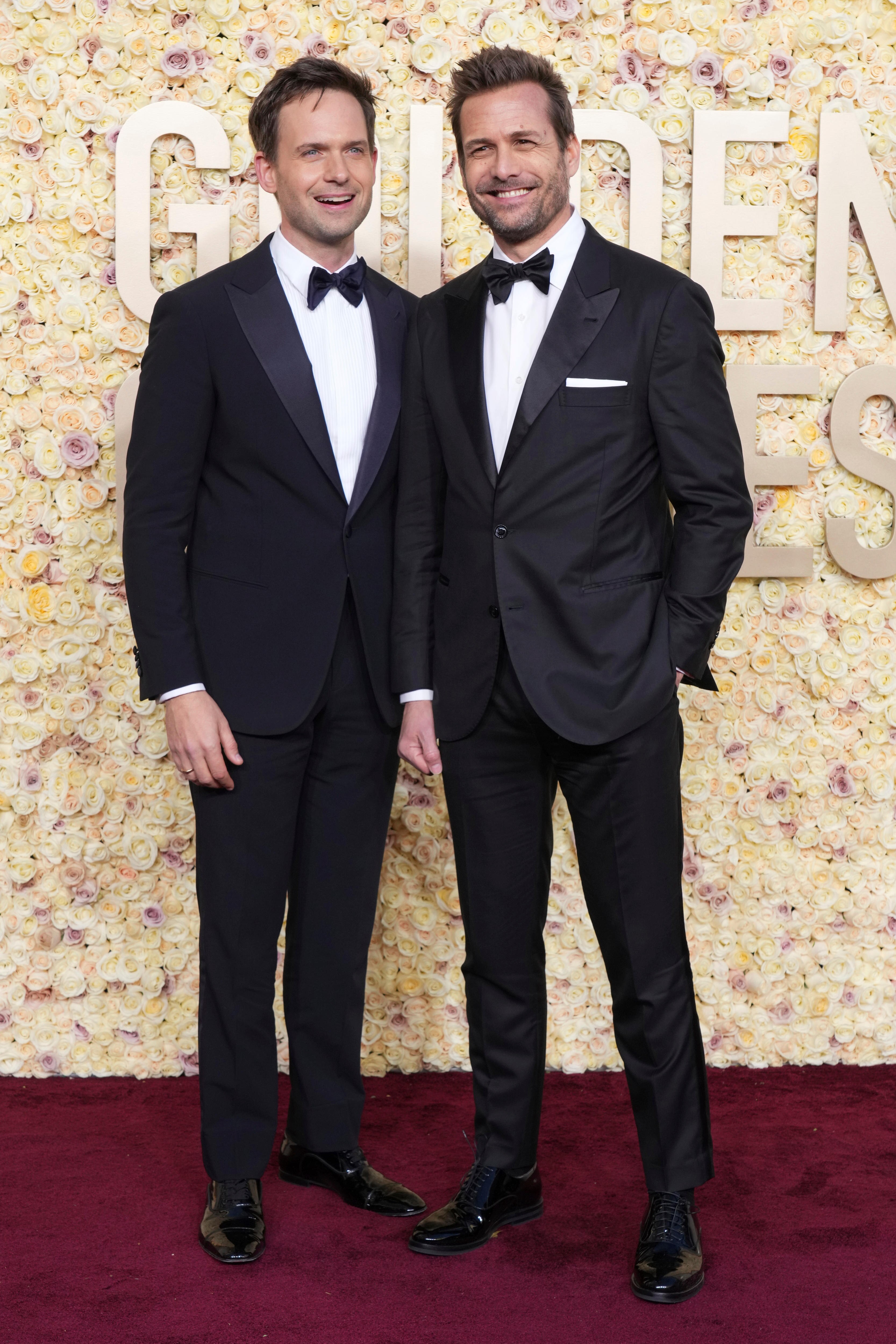Two actors on the red carpet both wearing black suits