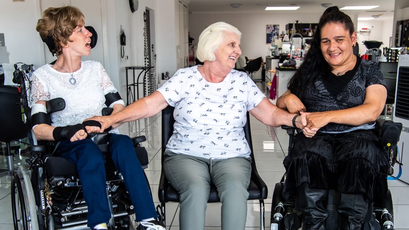 Ivy sits between Rachel and Tanya, who both use wheelchairs.