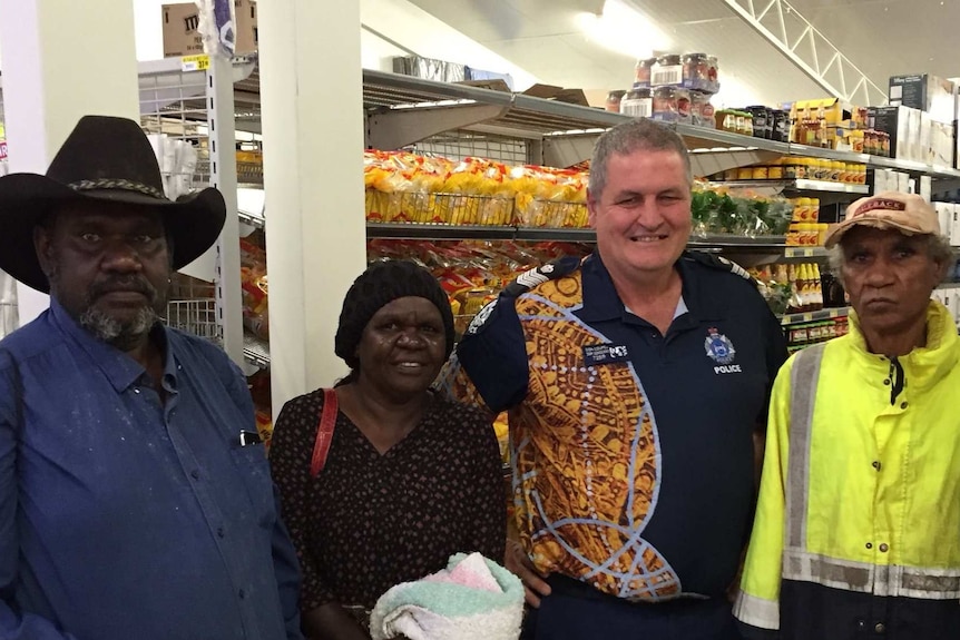 Don Couper standing in supermarket with three indigenous residents