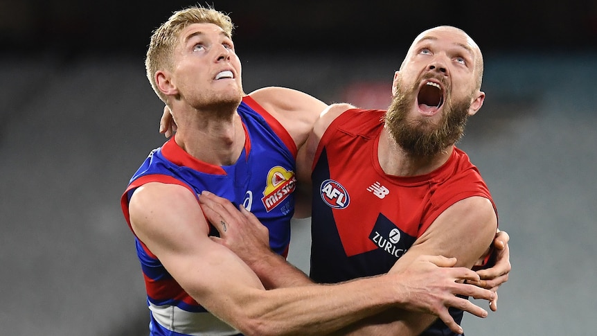 Two AFL players fighting for the ball during a match 