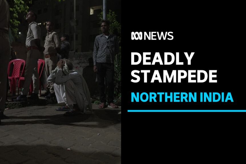 Deadly Stampede, Northern India: A man squatting holds his head in his hands on the street.