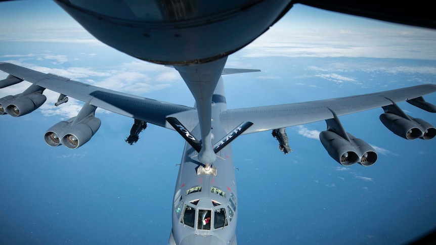 A image of a B-52 bomber being refueled mid-flight.