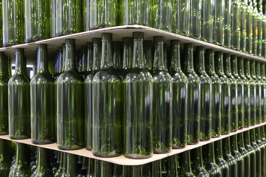 Rows of empty wine bottles stacked neatly