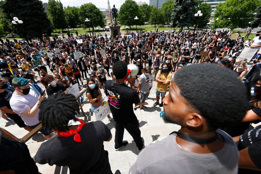 A speaker addresses demonstrators gathered outside the State Capitol to protest the death of George Floyd, in Denver.