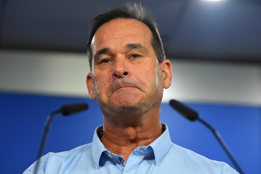 Todd Robinson speaks at a lectern at a press conference at police headquarters.