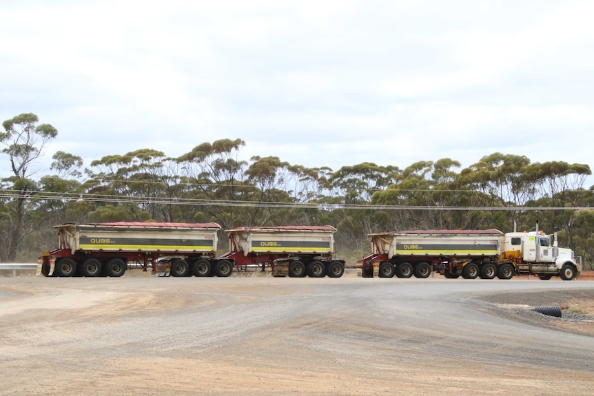 A three trailer road train parked on an outback road