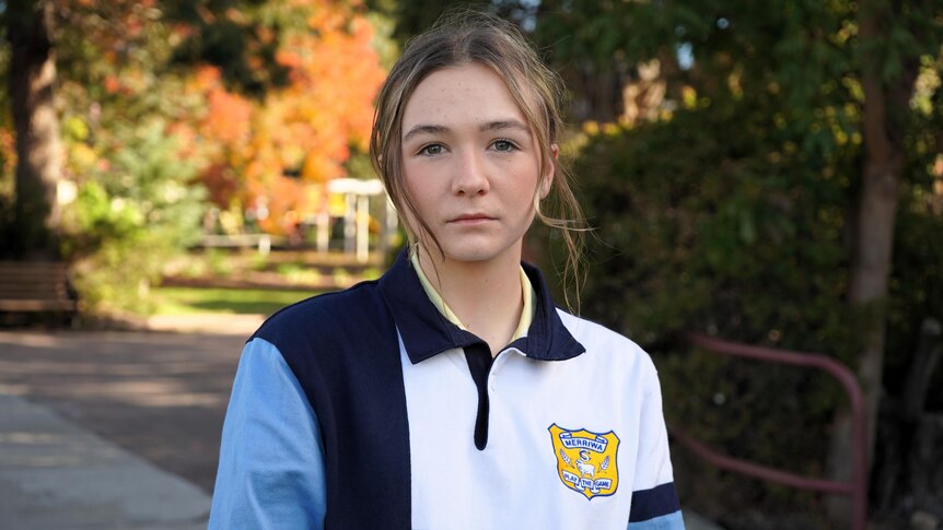A student, wearing her Merriwa Central School uniform, looks at the camera with a concerned expression