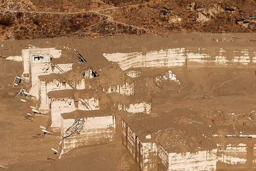 Light brown mud covers the ruins of a hydropower station