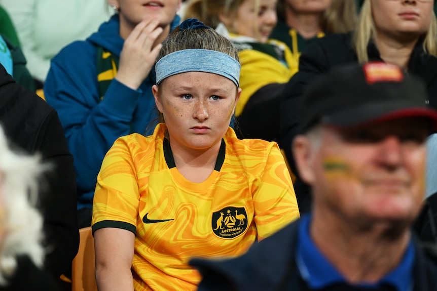 A concerned looking young football fan