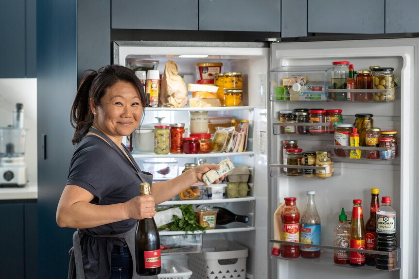 Nagi Maehashi standing in front of an open fridge
