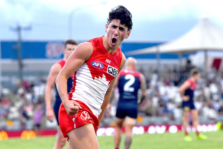 A Sydney Swans AFL player screams out in celebration after kicking a goal against Melbourne in Cairns.