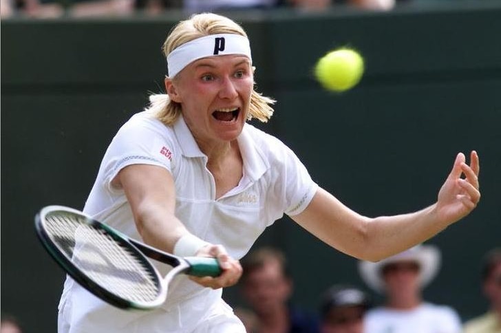 Jana Novotna runs in to hit a tennis ball coming towards her during the Wimbledon Tennis Championships in 1999.