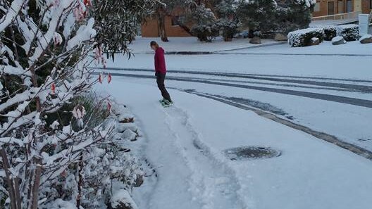 Chloe Owens sent us this photo of a friend snowboarding down the street in Jindabyne.