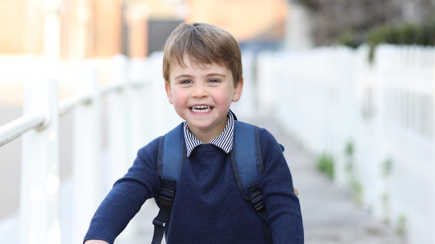 Britain's Prince Louis smiles on a red bicycle in a photo taken by his mother before his first day of school.