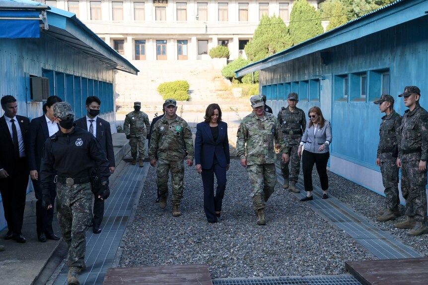Kamala Harris is flanked by military and other officials as she walks through the DMZ. 