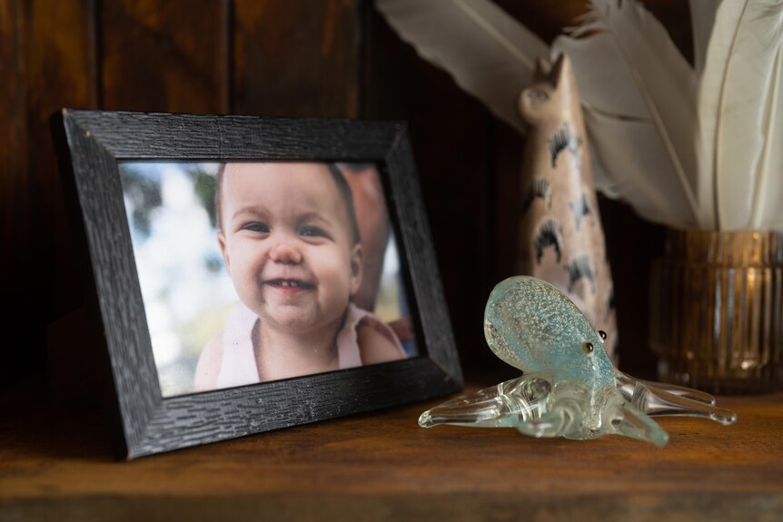 Picture of a smiling baby girl in a frame at a family home