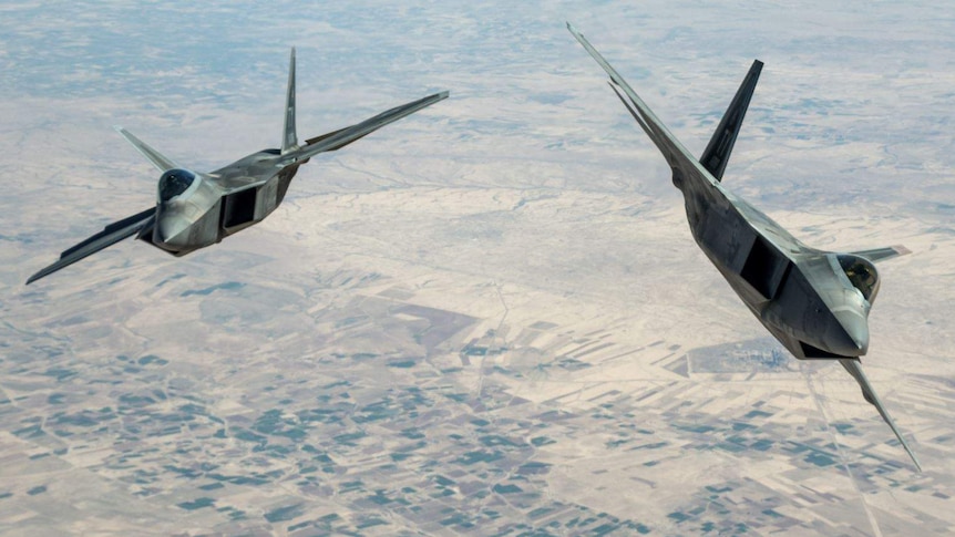 Two F-22 Raptors fly next to each other above Syria.