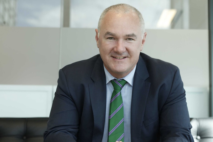 Profile shot of CoreLogic's head of research Tim Lawless sitting in an office wearing a suit.