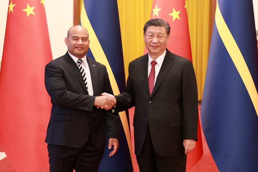 Chinese President Xi Jinping and Nauru's President David Adeang shake hands.