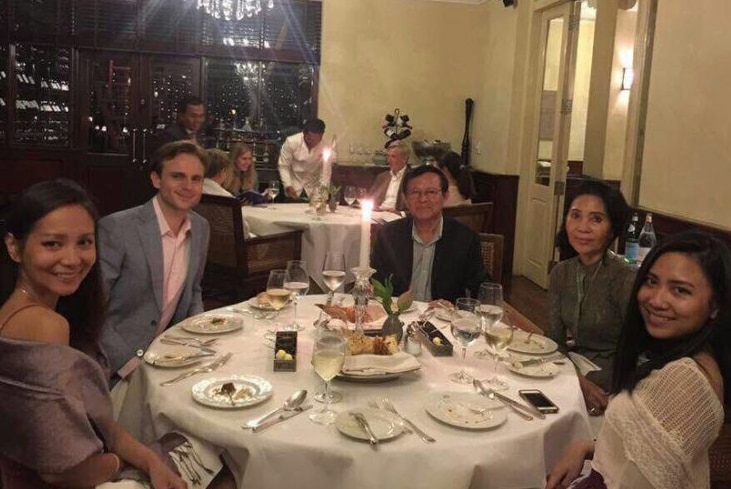 Kem Sokha sits at a table in a restaurant with his wife, two daughters and a man from a US embassy.