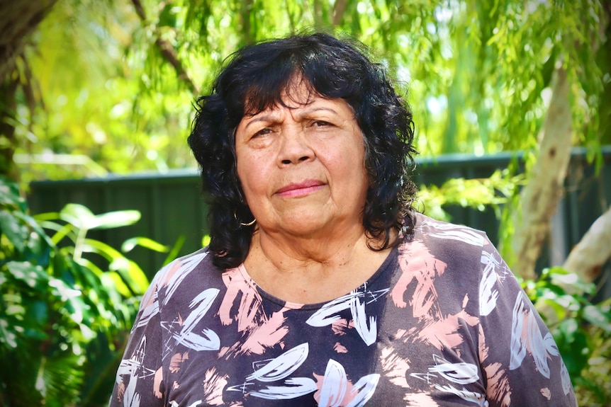 A woman looks at the camera with a worried expression