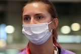 A close-up of Belarusian athlete Krystsina Tsimanouskaya wearing a mask at  Haneda international airport in Tokyo.