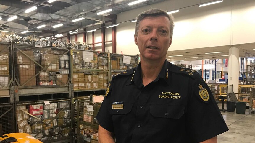 Tim Fitzgerald, NSW Regional Commander for Australian Border Force, standing in front on bail crates.