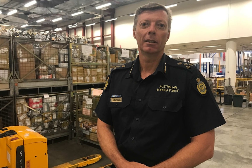 Tim Fitzgerald, NSW Regional Commander for Australian Border Force, standing in front on bail crates.